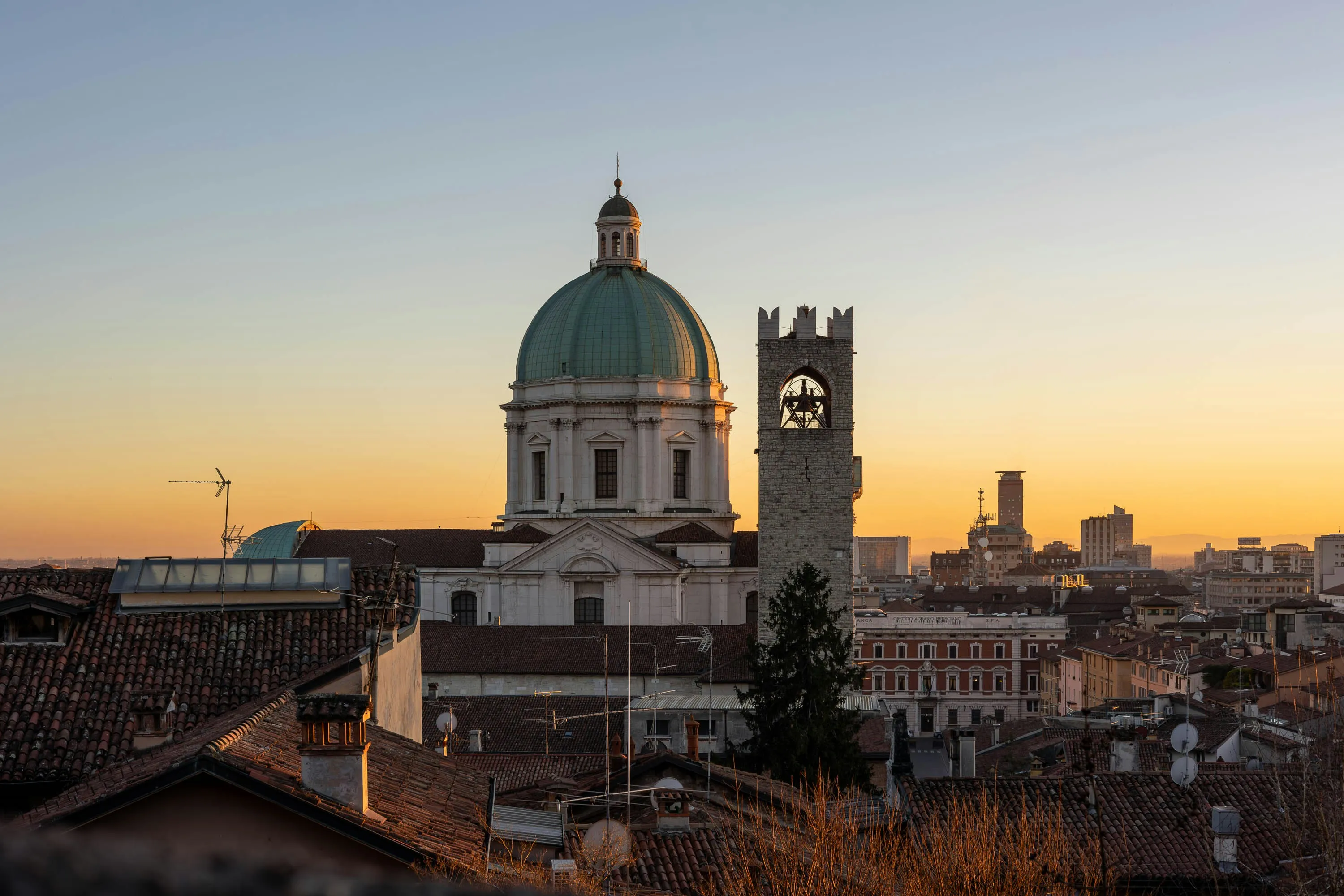 Brescia al tramonto: la cupola del Duomo Nuovo e la Torre del Pégol